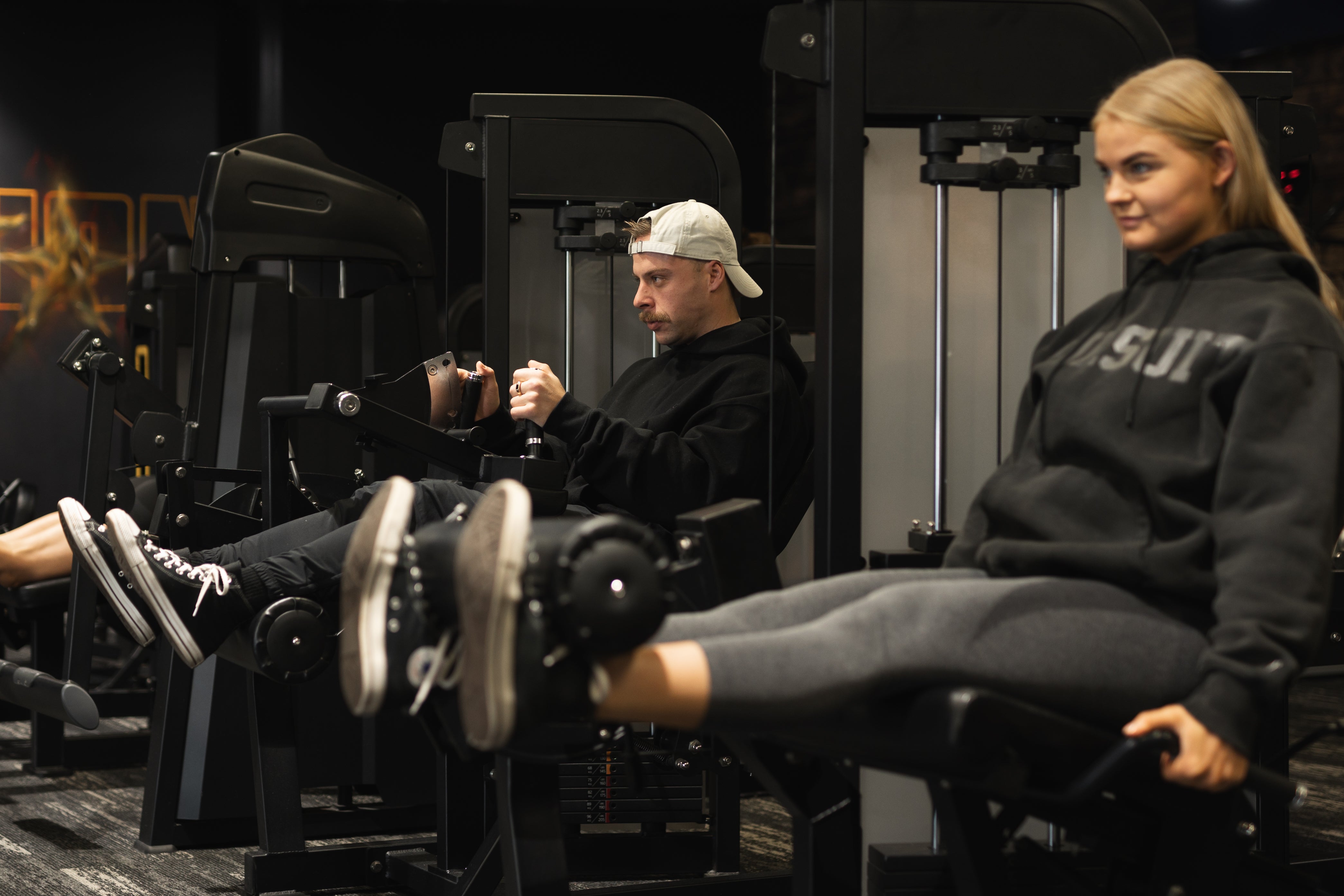 Members of Inception Gym working out on leg extension machines